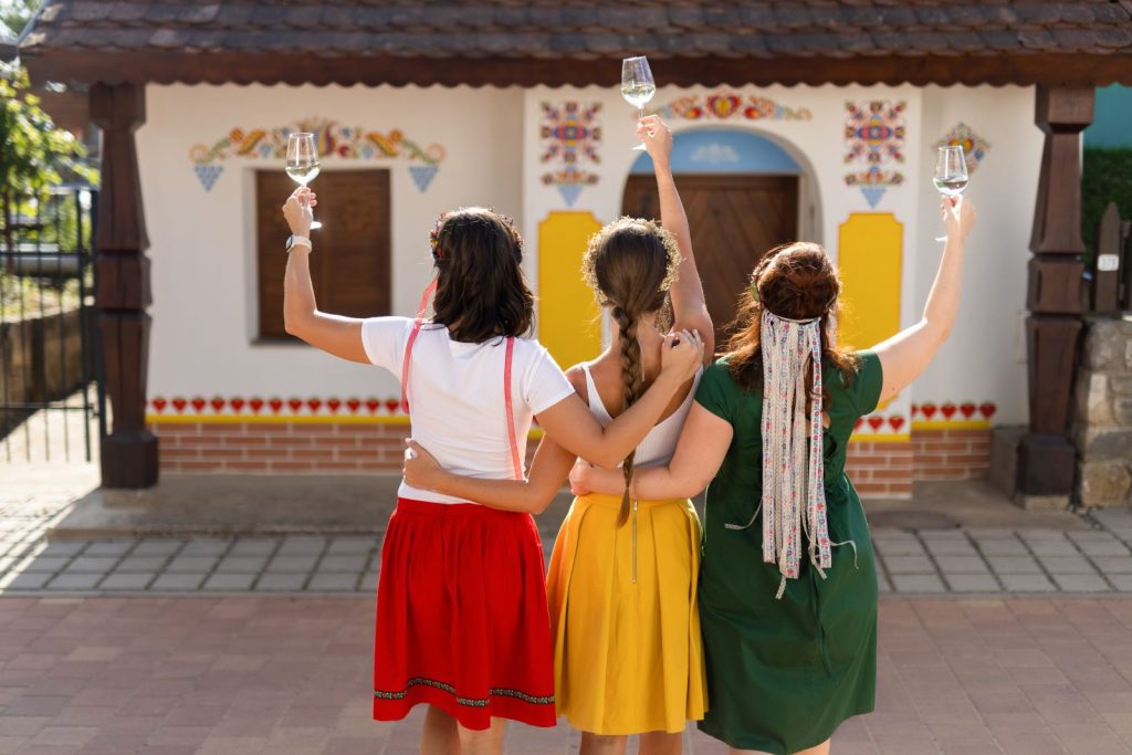 Three young women are raising glasses of wine in the Czech Republic.